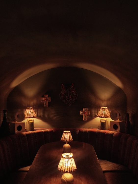 A banquette and table lamps in a vaulted room.