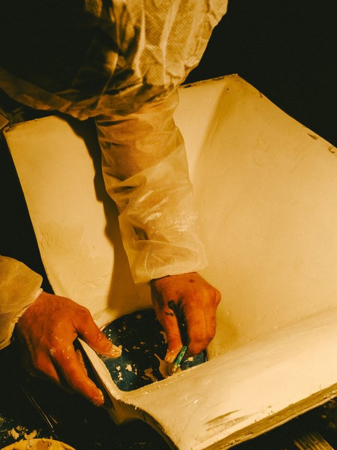 Hands finishing the shell of a hand built speaker cabinet.